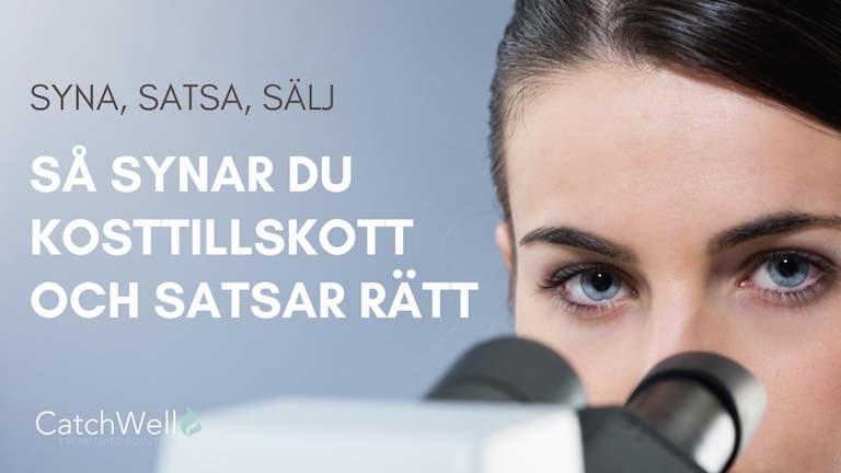 En kvinnas ögon vid mikroskop tittar mot kameran